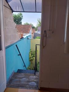 an open door to a balcony with a blue wall at Lollapalooza muy cerca in San Isidro