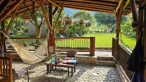 d'une terrasse avec un hamac, une table et des chaises. dans l'établissement Pradera Ecoliving, à Betania