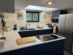a kitchen with a sink and a refrigerator at Bay Tree Barn in Truro