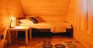 a small room with a bed in a wooden cabin at Gwiazda Północy Gołdap Dom na Wynajem in Gołdap