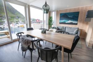 a dining room with a wooden table and chairs at High standard Lodge Ballstad in Ballstad