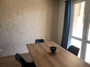 a wooden table with chairs in a room with a window at Maison de vacances avec piscine , dans résidence in Meschers-sur-Gironde +6 photos