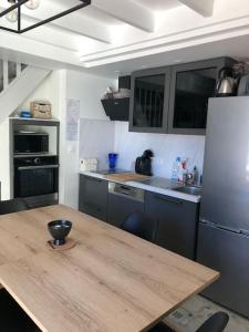 a kitchen with a wooden table and a refrigerator at Maison de vacances avec piscine , dans résidence in Meschers-sur-Gironde