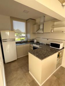 a kitchen with a white refrigerator and a counter top at TERRA - Departamento 2 in Esperanza