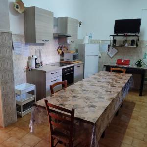 cocina con mesa con sillas y encimera en casa con giardino Arbus Sardegna, en Arbus