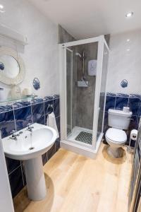 a bathroom with a shower and a sink and a toilet at Prospect House in Whitby