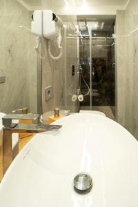 y baño blanco con ducha y aseo. en La Scogliera In, en Aci Castello
