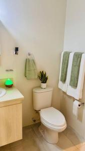 ein Badezimmer mit einem WC und einem Waschbecken mit Handtüchern in der Unterkunft Mid-Century Modern Charm in Discovery Bay