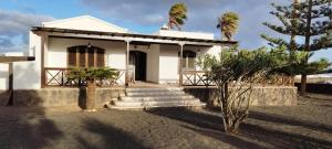 Casa Paraiso في سان بارتولومي: منزل أبيض صغير مع أشجار النخيل والدرج