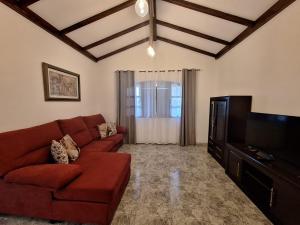 uma sala de estar com um sofá vermelho e uma televisão de ecrã plano em Casa Paraiso em San Bartolomé