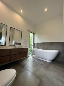 a bathroom with a large tub and two sinks and a toilet at Casa Totumbla in Estelí