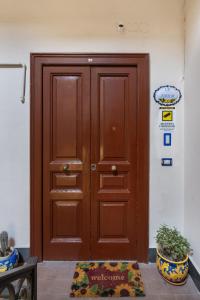 a wooden door in a building with a rug in front of it at LB Nanà in Castellammare di Stabia