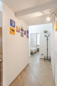 a hallway with a white wall with pictures on it at LB Nanà in Castellammare di Stabia