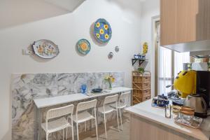 a kitchen with a counter with chairs and plates on the wall at LB Nanà in Castellammare di Stabia