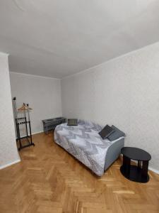 a bedroom with a bed and a table on a wooden floor at Велика 1к квартира біля метро Лівобережна вулиця Флоренції 1 in Kyiv