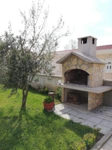 a stone pizza oven in the yard of a house at Apartments Zvonimir in Privlaka