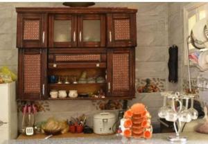 Bakar House في أسوان: مطبخ مع خزانة خشبية مع طعام فيها