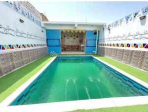 a swimming pool with green water in a building at Bakar House in Aswan