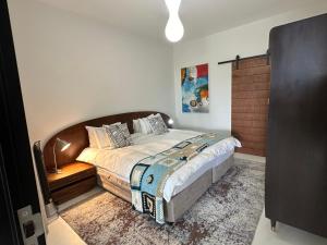 een slaapkamer met een groot bed met een houten hoofdeinde bij Constantia View Apartments OPERATIONAL DURING LOADSHEDDING in Kaapstad