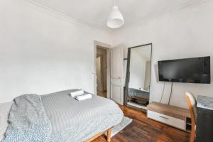 a bedroom with a bed and a flat screen tv at Wonderful apartment close Champs-Elysées in Paris