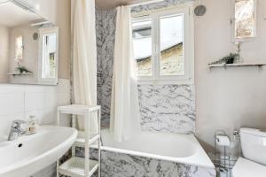 a white bathroom with a tub and a sink at Wonderful apartment close Champs-Elysées in Paris