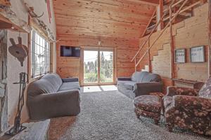 een woonkamer met banken en stoelen in een blokhut bij Wanderlust Cabin in Lead