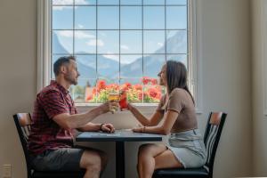 Ein Mann und eine Frau sitzen an einem Tisch in der Unterkunft Northwinds Hotel Canmore in Canmore