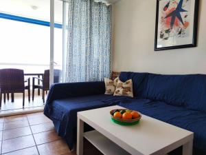 a living room with a blue couch and a bowl of fruit on a table at Mediterranean sea view apartment in Santa Ponsa