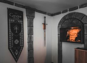un panneau sur un mur avec une cheminée dans l'établissement Suite privative Le seigneur des anneaux Gondor, à Vertaizon