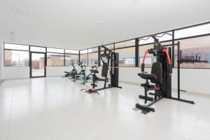 a gym with a row of treadmills and ellipticals at Apartamentos Weeki en Chapinero in Bogotá