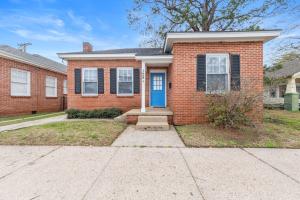 a red brick house with a blue door at Large Groups Welcome - 2 Homes Next Door in New Iberia