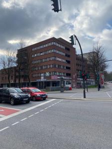 un semáforo con coches estacionados frente a un edificio en Pension King Royal, en Hamburgo