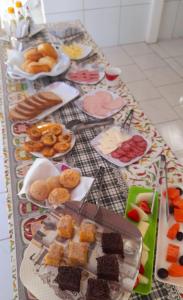 a table topped with lots of different types of food at Recanto Aconchego Itapoá in Itapoa