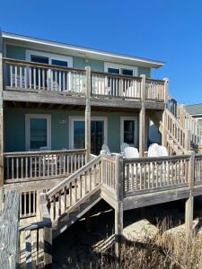 ein Haus mit einer großen Terrasse am Strand in der Unterkunft 2 if by Sea- East Unit in Emerald Isle