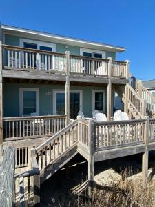 a house with a large deck on the beach at 2 if by Sea- East Unit in Emerald Isle