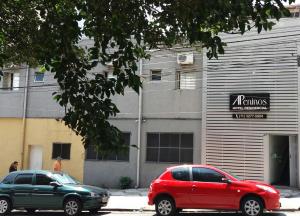 due auto parcheggiate di fronte a un edificio di Apeninos Suites Basicas a San Paolo