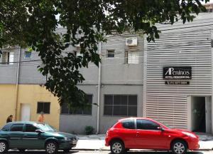 two cars parked in front of a building at Apeninos Suites Basicas in São Paulo
