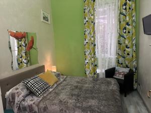 a bedroom with a bed and a chair and a window at Român Holidays in Rome