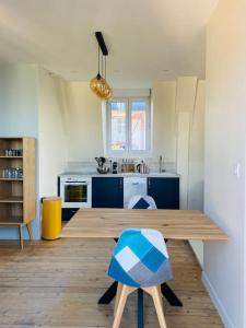 cocina con mesa de madera y armarios azules en Superbe Studio avec vue sur la mer à 180° en Villers-sur-Mer