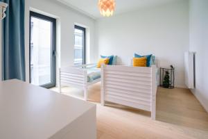 une chambre blanche avec une table et deux chaises dans l'établissement Vakantieappartement Oosteroever Oostende, à Ostende