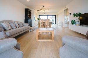 - un salon avec un canapé et une table dans l'établissement Vakantieappartement Oosteroever Oostende, à Ostende