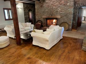 a living room with white couches and a fireplace at Dům U Dvou Líp / The Two Lime Trees in Mohren