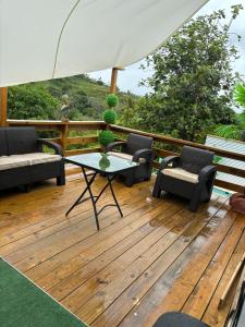 a deck with chairs and a table and an umbrella at Casita Kiri in San Sebastian