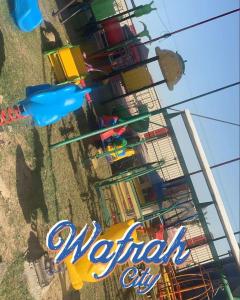 a view of a merry go round amusement park at Gamarah farm in Al Wafrah