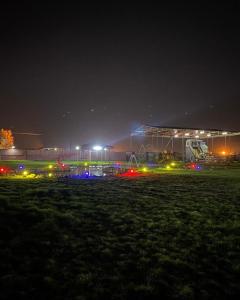 ein Fußballfeld in der Nacht mit einem Gebäude im Hintergrund in der Unterkunft Gamarah farm in Al Wafrah