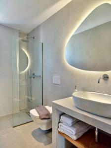 a bathroom with a sink and a toilet and a mirror at Sapphire apartment - Paros Gem in Naousa +9 photos