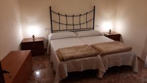 1 dormitorio con 1 cama grande y 2 mesitas de noche en Casa Rural Los Pequeños (Monserrat) en Monserrat