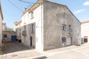 an old white building on the side of a street at Les appartements de l'horloge in Carcassonne