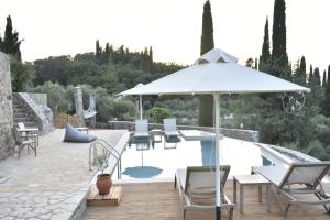 un patio con sombrilla y piscina en Corfu View Deluxe, en Perama