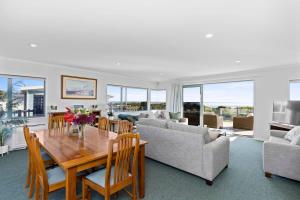 a living room with a table and a couch at Oceanview on Broadway in Waihi Beach
